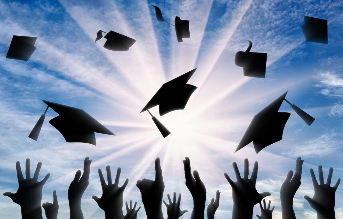 Graduation caps in air