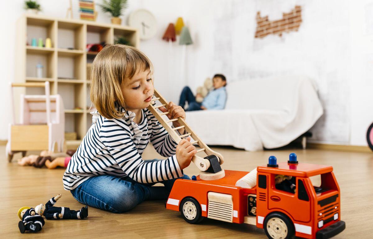 Child playing with toy fire truck