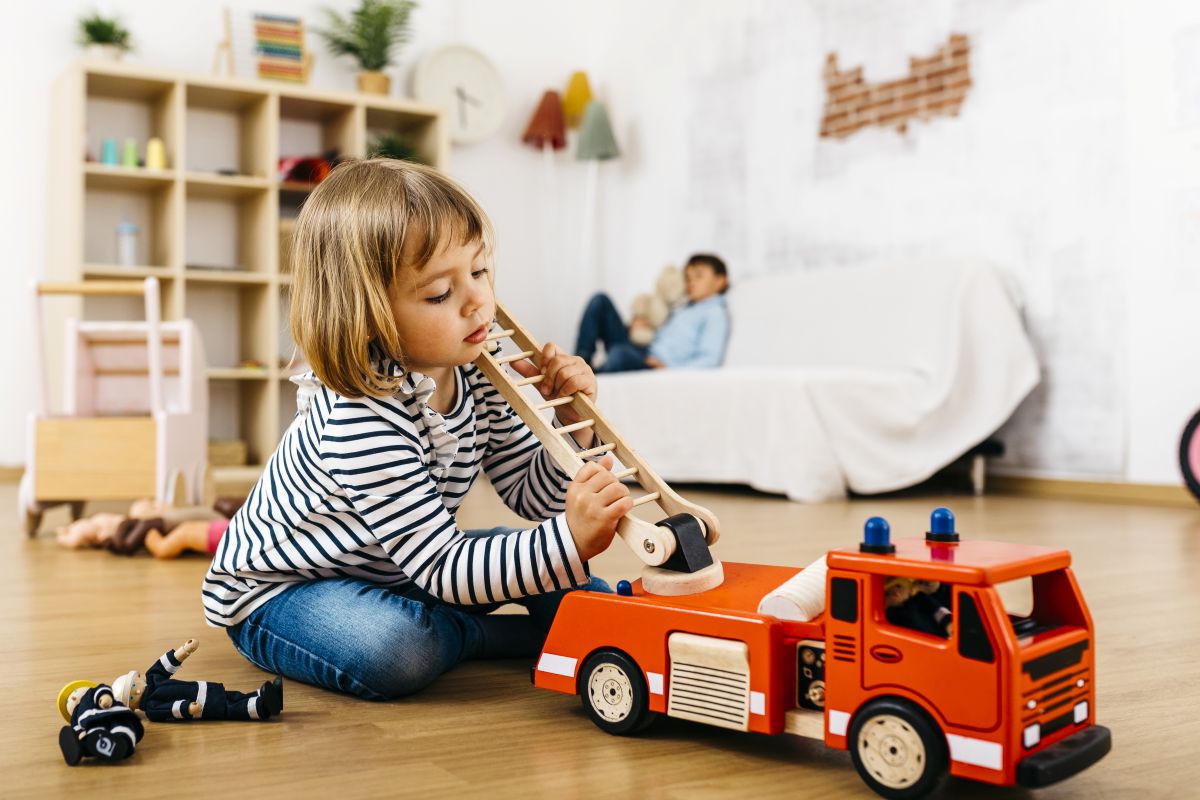 Child playing with toy fire truck