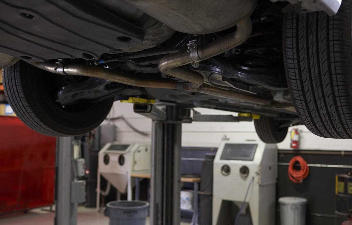 Car up on a lift at auto mechanic's shop