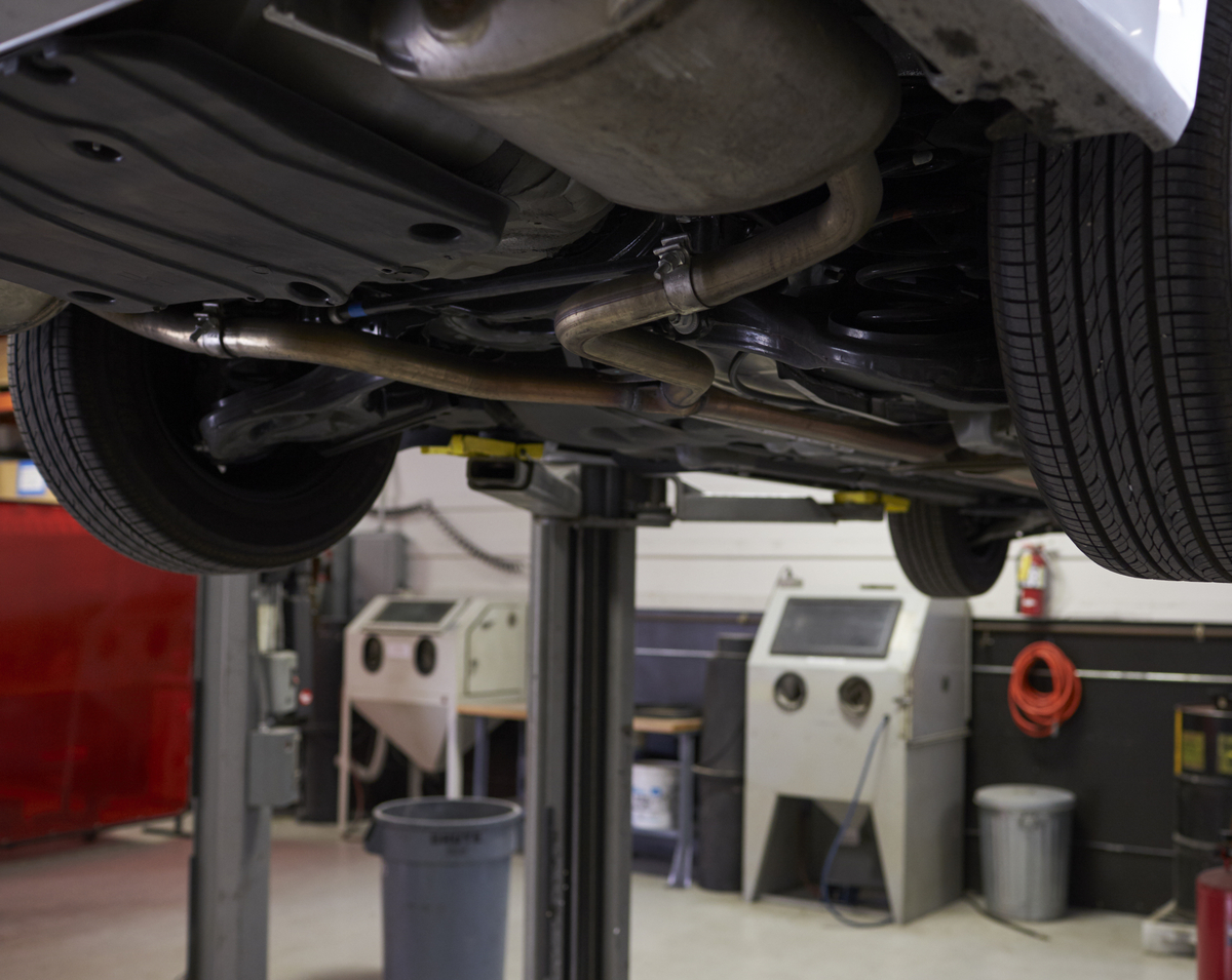 Car up on a lift at auto mechanic's shop