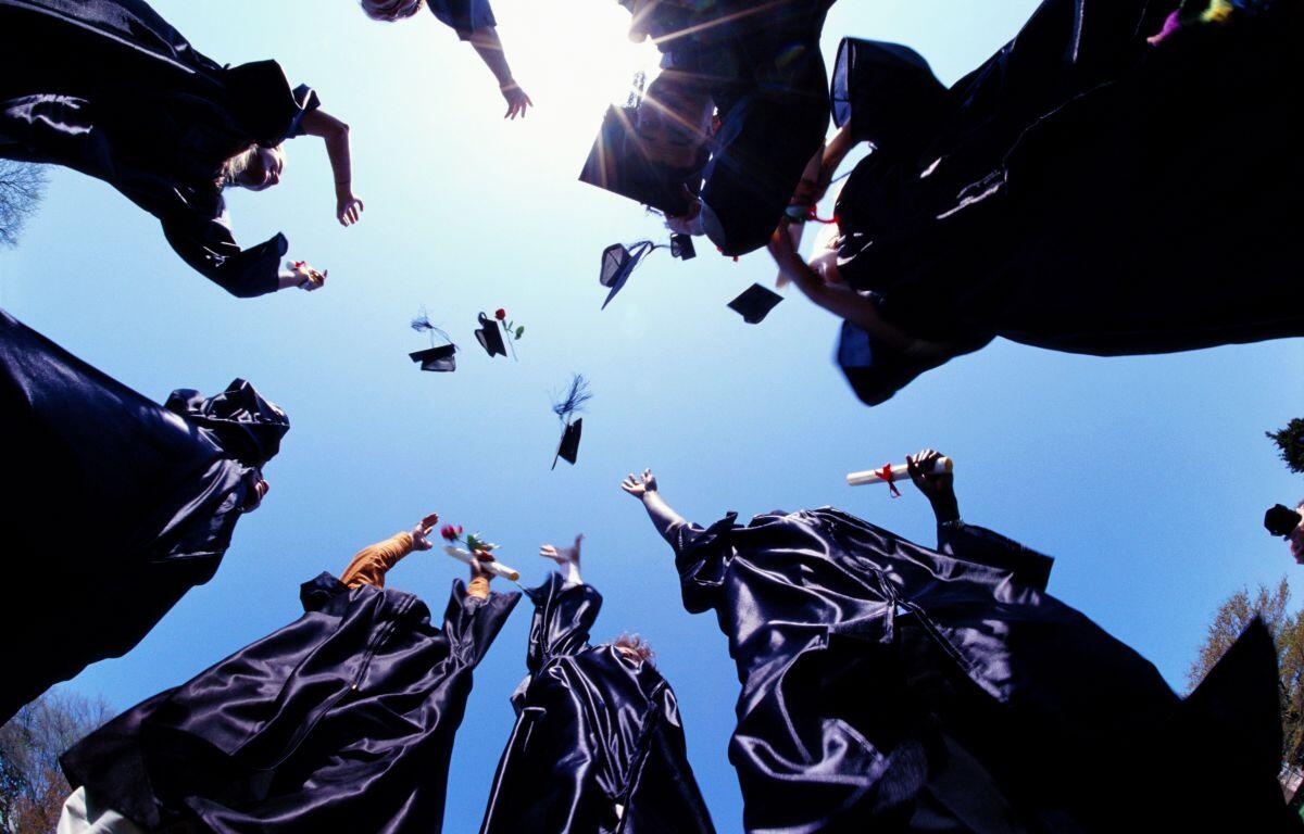 Graduates tossing caps into the air