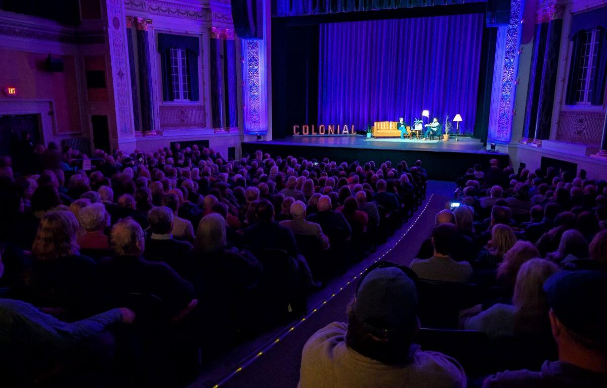 Colonial Theatre director Keith Marks interviews fillmaker Ken Burns after the American Revolution screening at the theater with the old marquee lettering onstage