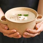 Person holding bowl of soup