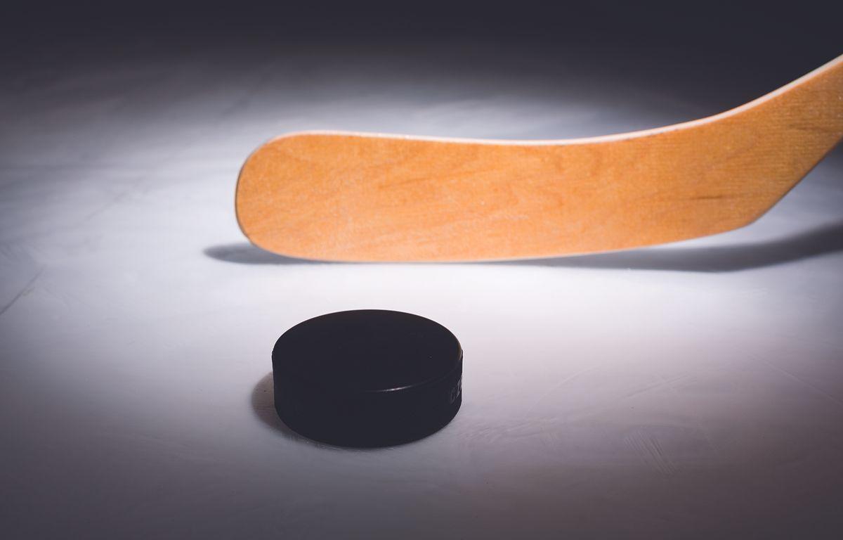 Hockey puck and stick on ice