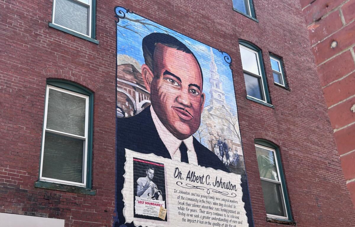 Mural on a brick wall showing a large portrait of Dr. Albert C. Johnston with a commemorative text panel beneath it
