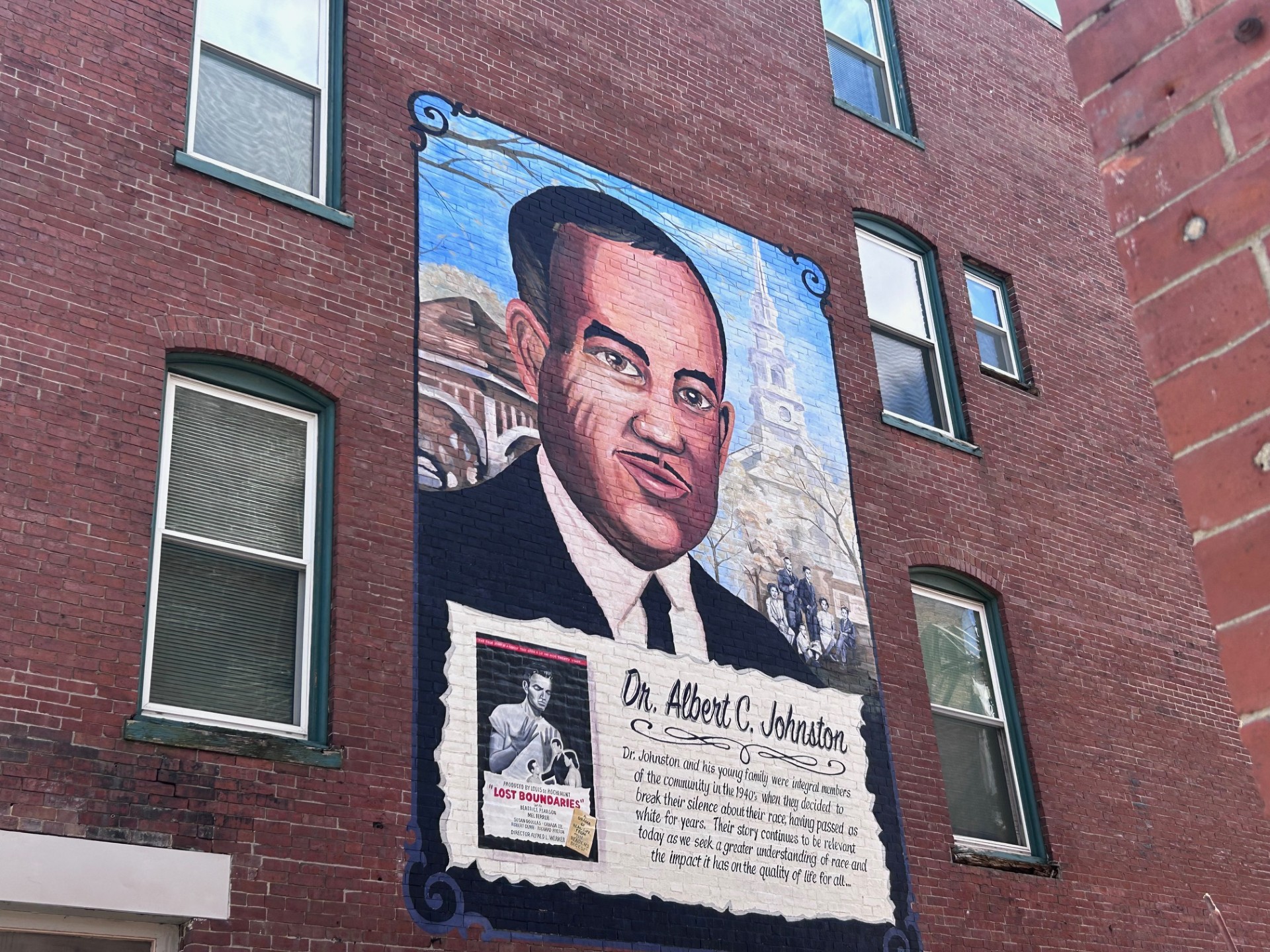 Mural on a brick wall showing a large portrait of Dr. Albert C. Johnston with a commemorative text panel beneath it
